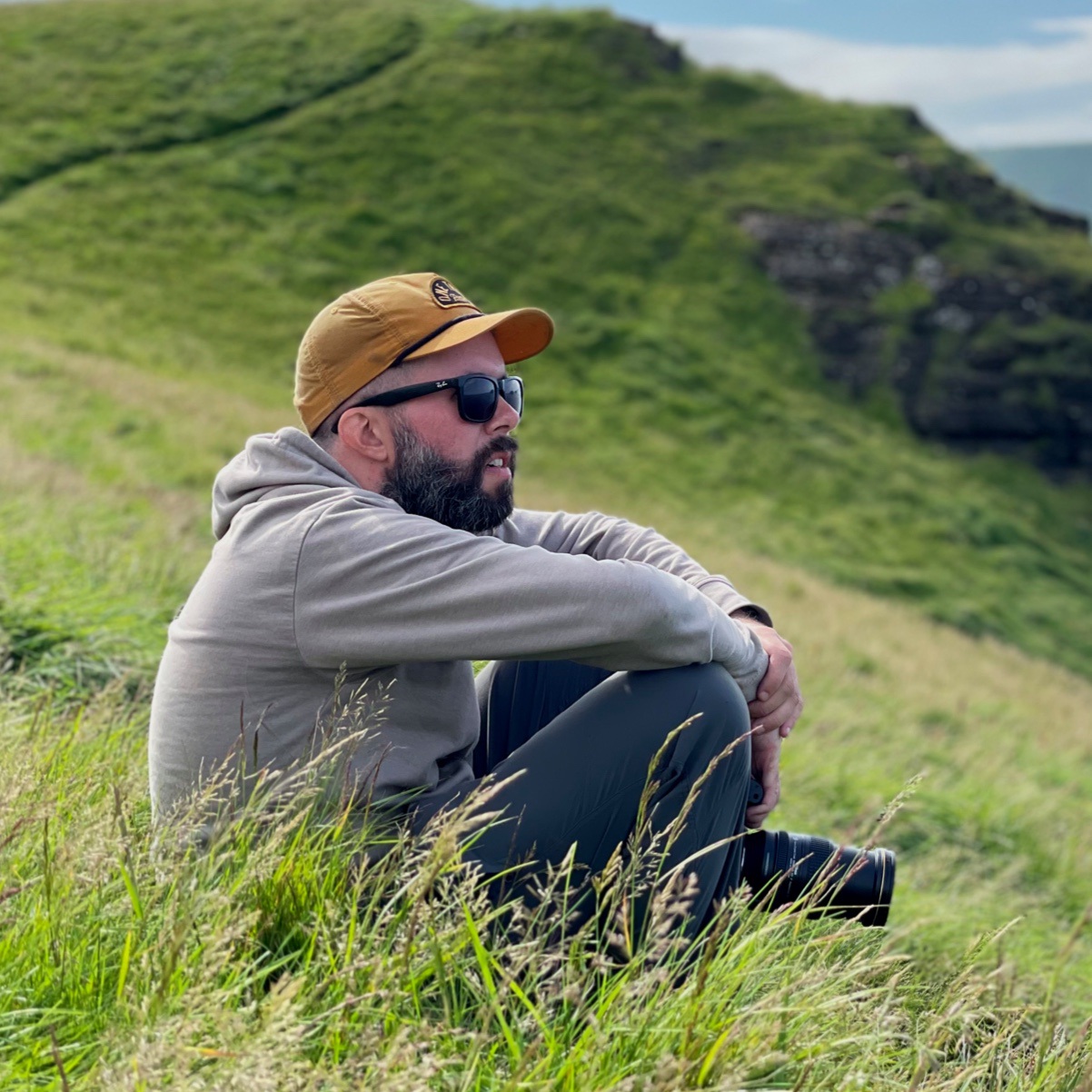 Mike sitting in the grass in Vestmannaeyjar