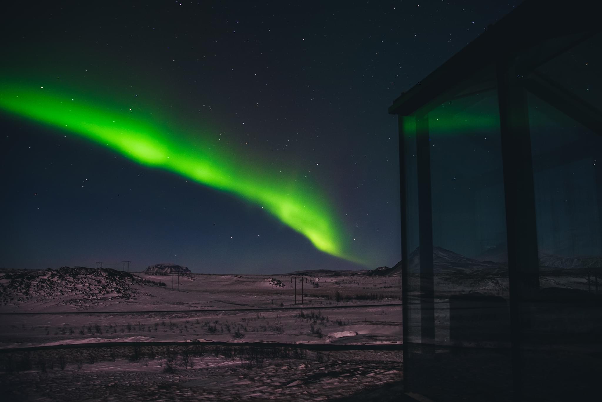 View of the Aurora Borealis next to Freya Lodge at Panorama Glass Lodge